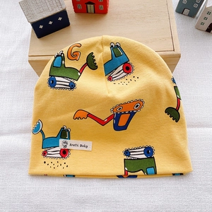 Detailed texture of yellow cotton knit baby hat with colorful cartoon excavator print