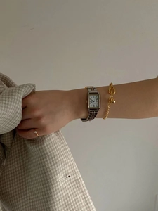 Detail of vintage gold quartz watch with Roman numerals and matching gold chain bracelet