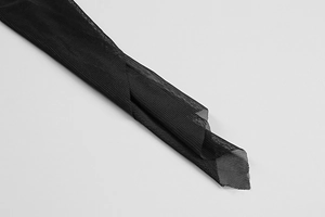 Detailed close-up of semi-transparent black micro-mesh fabric texture and knitting
