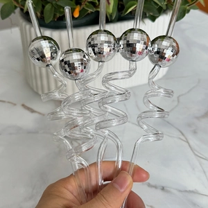 Close-up of five spiral disco ball straws held by hand for retro party decoration