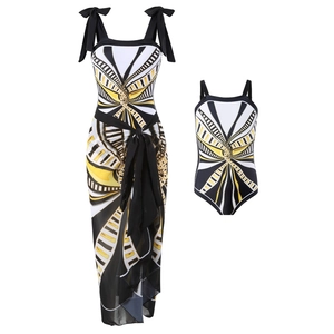 Detail view of matching mother-daughter swimsuits with yellow and black geometric patterns