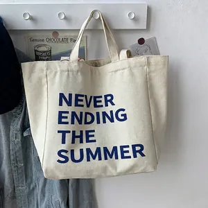 Detail of canvas tote bag with dual straps and 'Never Ending Summer' navy blue typography