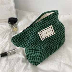 Detailed close-up of emerald green houndstooth makeup bag with vintage metal zipper