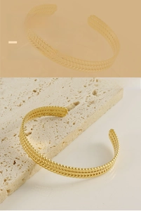 Detailed macro view of 18K gold plated stainless steel bracelet with wheat pattern texture