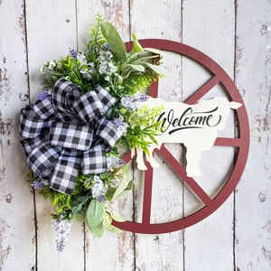 Farmhouse Christmas wreath with red wheel, white cow silhouette and buffalo check bow