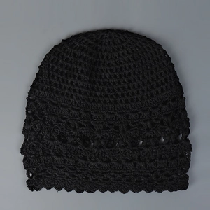 Vista detallada del gorro de ganchillo negro hecho a mano con un delicado calado.