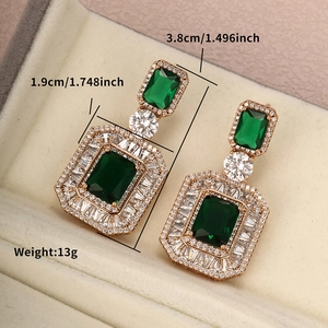 Macro detail of luxury teardrop emerald earrings with dimension and weight markings