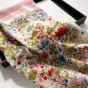 Close-up of floral silk scarf with colorful botanical patterns and pink striped borders