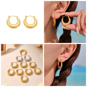 Detailed view of U-shaped hoop earrings with scale texture in gold and silver plating