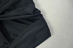 Macro detail of the elegant black fabric showing professional pleated design texture