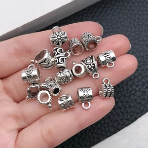 Dettaglio di ganci per ciondoli in lega argento con motivi floreali e a cuore vintage