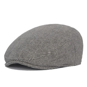 Detail shot of grey herringbone wool newsboy cap showing tweed fabric texture