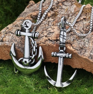 Macro detail of retro anchor pendants on natural wood and moss background