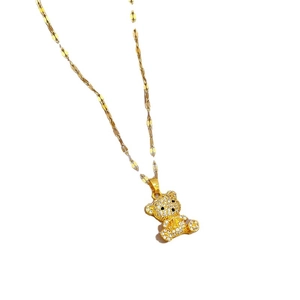 Golden titanium steel teddy bear necklace with sparkling crystals on white background