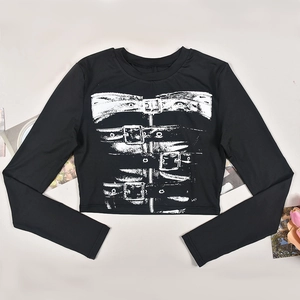 Close-up of black crop top with white biker-style print and metallic detail graphic
