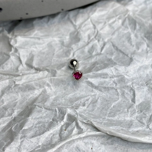 Macro view of pink heart-shaped zircon ear stud with silver screw ball back closure
