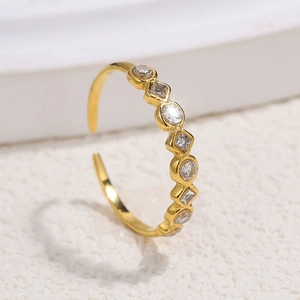 Macro view of gold adjustable ring with alternating round and diamond-shaped zircons