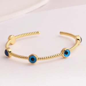 INS style gold-plated open bangle with blue evil eye charms on twisted rope band