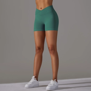 Dettaglio degli shorts da yoga verde scuro senza cuciture con elegante vita alta a V incrociata