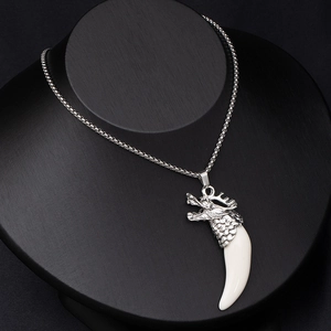 Detail of silver dragon head necklace featuring a curved faux wolf tooth on a black bust