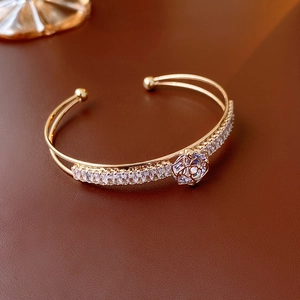 Macro detail of gold-plated double-layer bracelet with zircon flower and hollow rose design