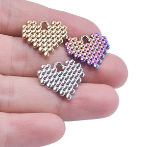 Close-up of heart-shaped stainless steel pendants in gold, silver, and rainbow plating