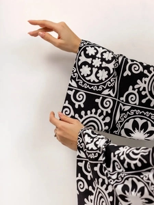 Close-up of wide cuff with black and white floral print on a long sleeve pajama set