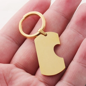 Polished gold titanium steel keychain with rectangular tag held in a palm