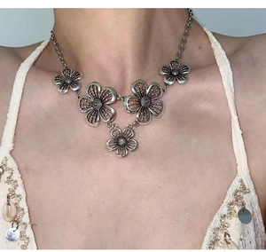 Detail view of five hollow flower pendants on a bohemian silver metal necklace