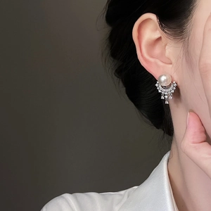 Detail of silver pearl tassel earring with pavé diamonds on a model for elegant look