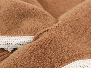 Vue macro d'un tricot marron avec une bordure élégante en dentelle blanche