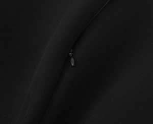 Detailed close-up of a high-quality black invisible zipper on woven fabric clothing