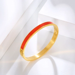 Detailed close-up of red enamel and gold-plated stainless steel narrow hinge bracelet