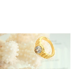 Detail view of gold textured band ring with a sparkling clear cubic zirconia stone