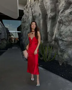 Detail of red satin slip midi dress featuring a deep V-neck and elegant draped silhouette