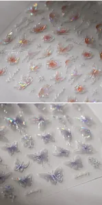 Vista macro di adesivi 3D olografici laser per unghie con farfalle e decori floreali