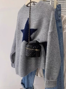 Minimalist grey long-sleeve knitted sweater with blue star motif and gold chain bag
