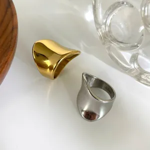 Minimalist irregular curved wide band rings in polished gold and silver stainless steel