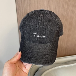Close-up detail of vintage washed denim baseball cap with white Forever letter embroidery