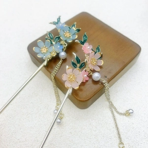 Close-up of traditional Chinese hairpins with flower petals, pearls and long metal tassels