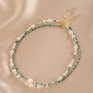 Detail of double-layer necklace with natural pearls and turquoise on silk background