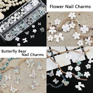 Macro shot of 3D aurora butterfly, white flowers and resin bears for nail art decoration
