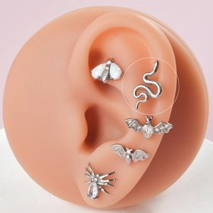 Détail d'un clou d'oreille serpent en acier inoxydable sur modèle d'oreille