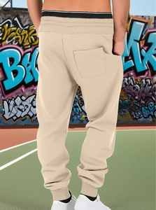 Detail view of beige joggers featuring a color-block waistband and single back pocket
