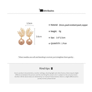 Detail showing wheat ear design earrings with pearls and zircon on white background