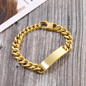 Golden stainless steel curb chain bracelet with blank ID tag on grey wood background