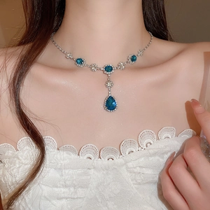 Dettaglio della lussuosa collana con pendente a goccia, cristalli blu e catena d'argento