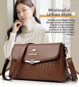 Detailed view of brown woven crossbody bag featuring a golden kangaroo logo and floral buckle
