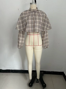 Detail of vintage plaid cropped top featuring double-layered cape design and high collar