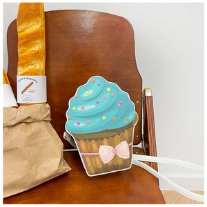 Macro detail of cupcake bag with pink bow, colorful sprinkles and white shoulder strap